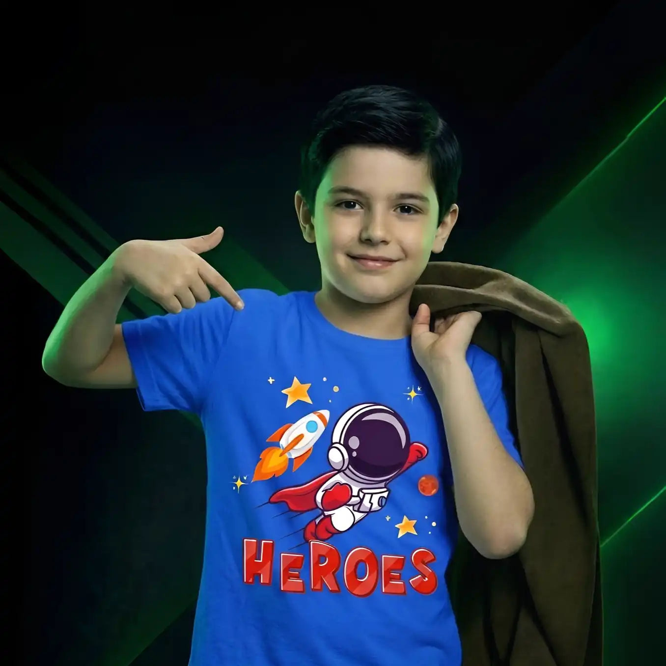 Child wearing a blue t-shirt with a superhero design and 'HEROES' text, posing against a dark background.