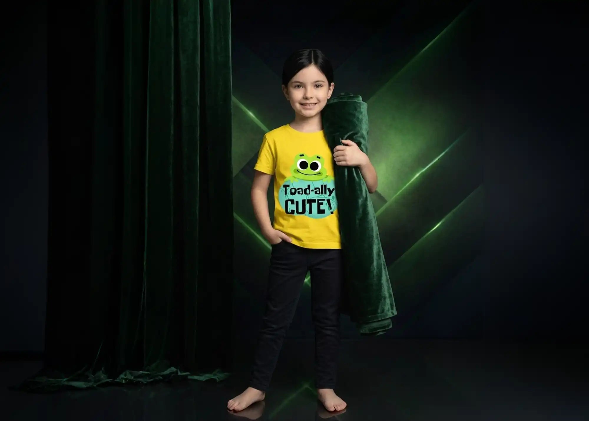 Child wearing a yellow shirt with a green character and text, standing against a dark background.