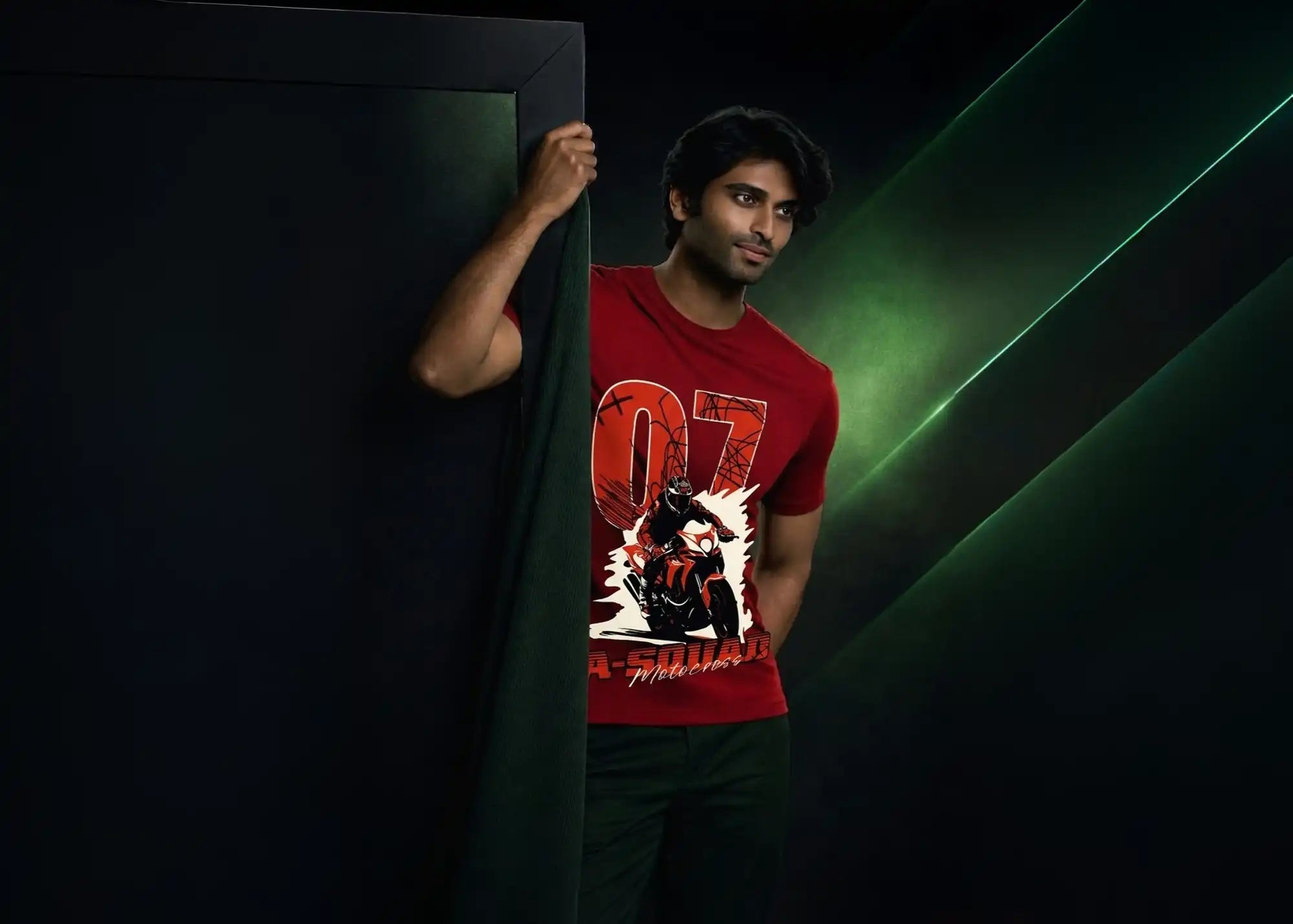 Man wearing a red t-shirt with a graphic design, standing against a dark background.