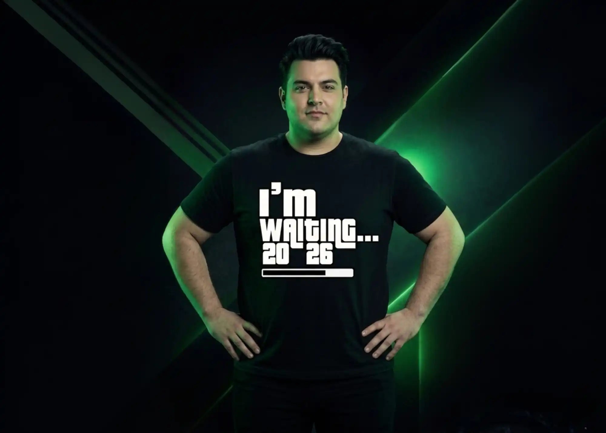 Person wearing a black t-shirt with text 'I'm waiting... 2026' against a dark background with green accents.